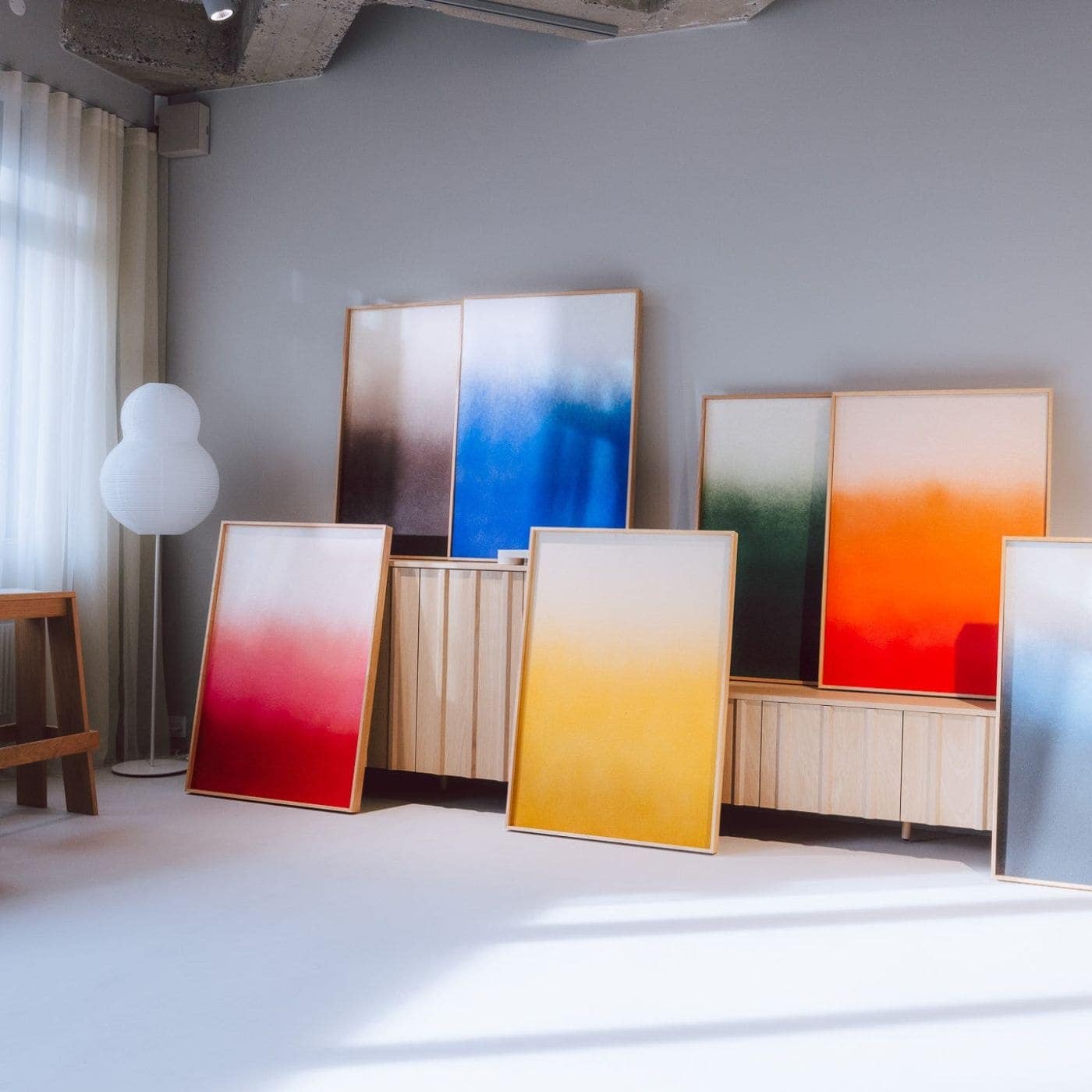 Colorful decorative sound absorbing panels with gradient designs displayed in a bright modern interior